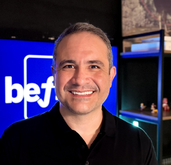 Pedro Duarte sorrindo, em frente a um painel azul com o logo da Befree